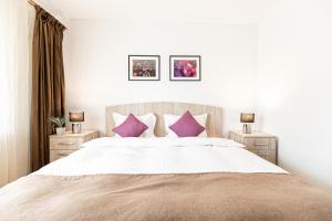 a bedroom with a large bed with purple pillows at Montana Apartment City Center in Braşov