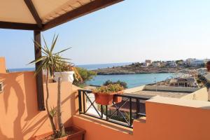 a balcony with potted plants and a view of the ocean at Hotel Medusa in Lampedusa