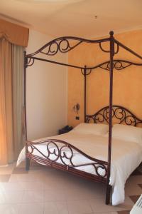 an iron canopy bed in a bedroom at Hotel Medusa in Lampedusa