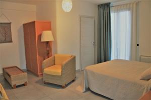 a bedroom with a bed and a chair at Hotel Medusa in Lampedusa