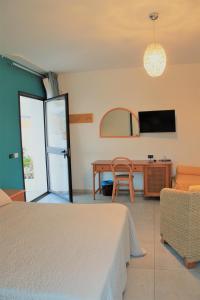 a bedroom with a bed and a table and a tv at Hotel Medusa in Lampedusa