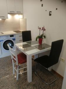 une table blanche avec deux chaises et un lave-linge dans l'établissement Apartma ROK, à Ankaran