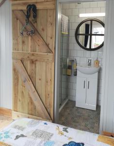 a bathroom with a wooden door and a sink at McHugh's Loft in Rathmullan