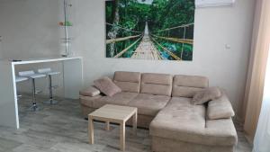 a living room with a couch and a painting on the wall at Apartament na Federacii 130a in Ulyanovsk