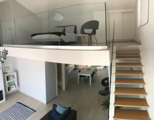 a staircase in a living room with a bedroom at 20 da Vila - Apartment With Mezzanine With Panoramic Terrace in São Bartolomeu de Messines