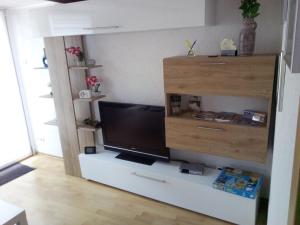 ein Wohnzimmer mit einem TV auf einem weißen Schrank in der Unterkunft Haus Hazienda in Briedel