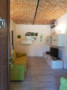 een woonkamer met een bank en een televisie bij Casa Serra in Asti