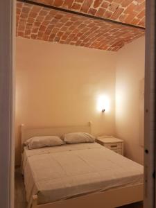 een slaapkamer met een bed en een bakstenen plafond bij Casa Serra in Asti