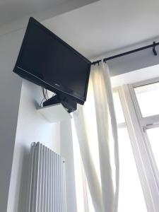 a flat screen tv on a wall next to a window at Sopotkowo Centrum in Sopot