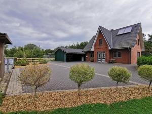a house with a solar roof on a driveway at Traumhaftes Ferienhaus an der Nordseeküste in Otterndorf
