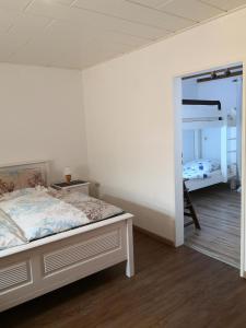 ein Schlafzimmer mit einem Bett und einem Etagenbett in der Unterkunft Ostfriesisches Landhaus in Wittmund