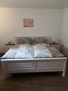 ein Bett in einem Zimmer mit zwei Nachttischen und zwei Tischen in der Unterkunft Ostfriesisches Landhaus in Wittmund