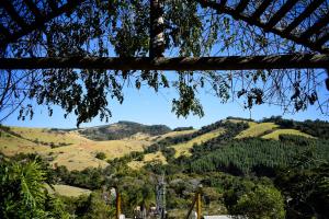 een uitzicht op de heuvels vanaf een boom bij Pousada A Mata que Canta in Socorro