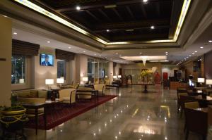 a lobby of a hotel with tables and chairs at Ramee Guestline Hotel in Muscat
