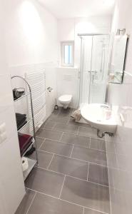a white bathroom with a sink and a toilet at H-Apartment 2 in Triberg