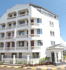 a white building with balconies on it at Coastgate Hotel in Mombasa