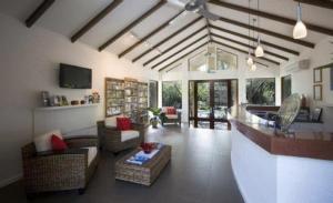 una gran sala de estar con sofás y una mesa. en Port Douglas Sands Resort en Port Douglas
