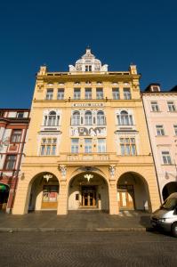 un gran edificio amarillo con un cartel. en Zvon Design Suites, en České Budějovice