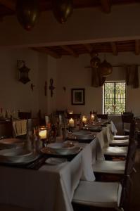 une salle à manger avec des tables blanches, des chaises et des bougies dans l'établissement Auberge Chez Pierre, à Boumalne