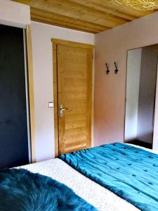 1 dormitorio con 1 cama y puerta de madera en Bel appartement avec vue exceptionnelle en Le Grand-Bornand