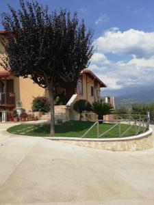 una casa con un árbol y una valla en La Quercia, en Cosenza