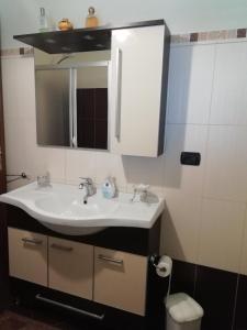 ein Badezimmer mit einem weißen Waschbecken und einem Spiegel in der Unterkunft La Quercia in Cosenza