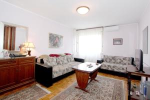 ein Wohnzimmer mit einem Sofa und einem Tisch in der Unterkunft Bohemian Rhapsody NBG in Belgrad