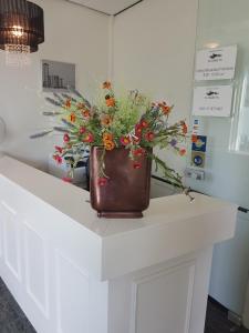 a vase with flowers sitting on top of a counter at Stad & Strandhotel Elisabeth in Vlissingen