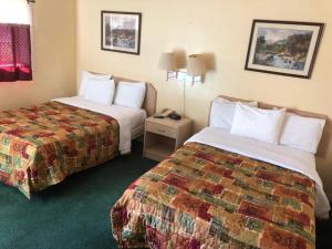 a hotel room with two beds and a night stand at Sunset Motel in Athens