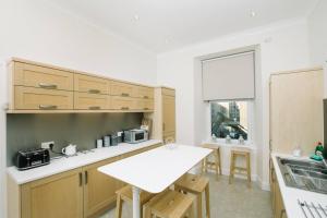 a kitchen with wooden cabinets and a white counter top at Great location! Heart of City Centre 3bed apartment in Edinburgh