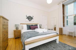 a white bedroom with a large bed and a window at Great location! Heart of City Centre 3bed apartment in Edinburgh