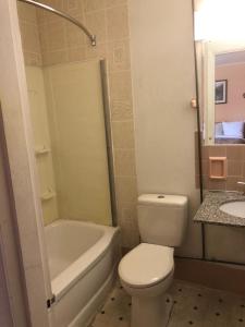 a bathroom with a toilet and a tub and a sink at Sunset Motel in Athens