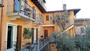 un edificio naranja con escaleras y balcones en él en Ca' due Olivi, en Toscolano Maderno