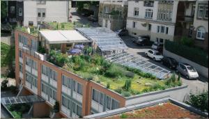 an apartment building with a garden on the roof at Abalon Hotel ideal in Stuttgart