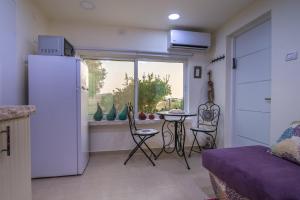 kuchnia z lodówką, stołem i oknem w obiekcie Or Gani w mieście Arad