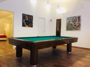 een pooltafel in een kamer met schilderijen aan de muur bij Kala Rooms in Palermo