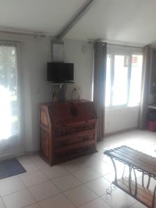 - un salon avec une télévision et une commode en bois dans l'établissement Maison proche de Paris 15 minutes, à Deuil-la-Barre