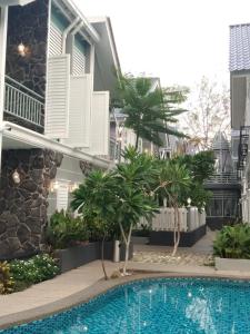 a swimming pool in front of a house at Royale Chenang Resort in Pantai Cenang