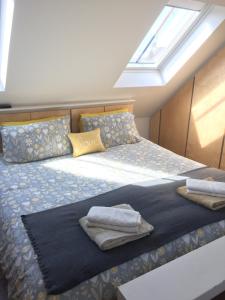 1 dormitorio con 1 cama con toallas en Stans Place Self Catering Cottage en Malmesbury