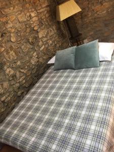 ein Schlafzimmer mit einem Bett mit einer Steinmauer in der Unterkunft Casa do Tuga in Bragança