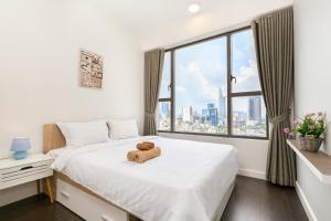 a teddy bear sitting on a bed in a room with a window at TeeUp Home - Infinity Pool Signature in Ho Chi Minh City +152 photos