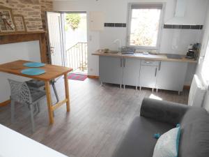 a living room with a table and a kitchen at Chez Papy et Mamie in Aubazines