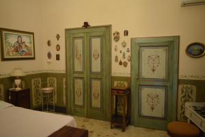 a bedroom with two green doors in a room at Appartamento Il Campanile in Muro Leccese