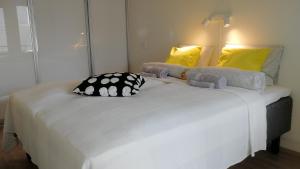 duże białe łóżko w pokoju z żółtymi poduszkami w obiekcie Feels like Home City Holvi w mieście Jyväskylä