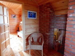 Habitación con chimenea de ladrillo y silla en Dom na Roztoczu, en AdamÃ³w