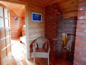 a room with a brick fireplace and a chair at Dom na Roztoczu in AdamÃ³w