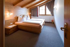 A bed or beds in a room at Gästehaus Brantlhof Zimmer und Ferienwohnungen in Going am Wilden Kaiser
