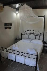 a bedroom with a bed with white sheets and pillows at Anemos - Holiday Beach Houses in Keratokampos