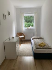um quarto com uma cama, uma secretária e uma janela em Akazienhof em Seelenberg