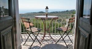 a table and two chairs on a balcony at Guesthouse Parthenon in Parthenonas